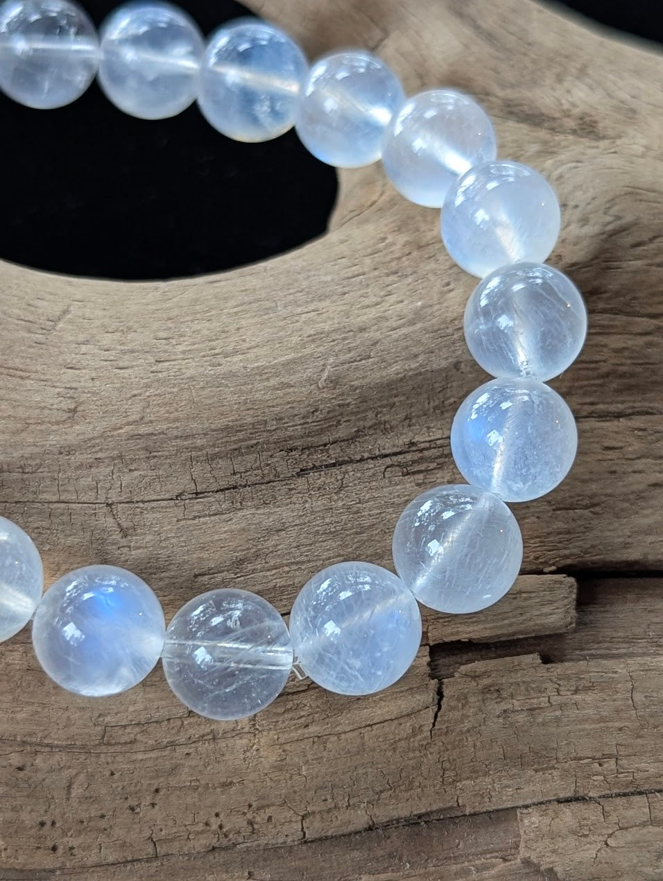 Macro detail shot of 10mm Sri Lankan White Moonstone beads showing clean structure and brilliant blue adularescence.
