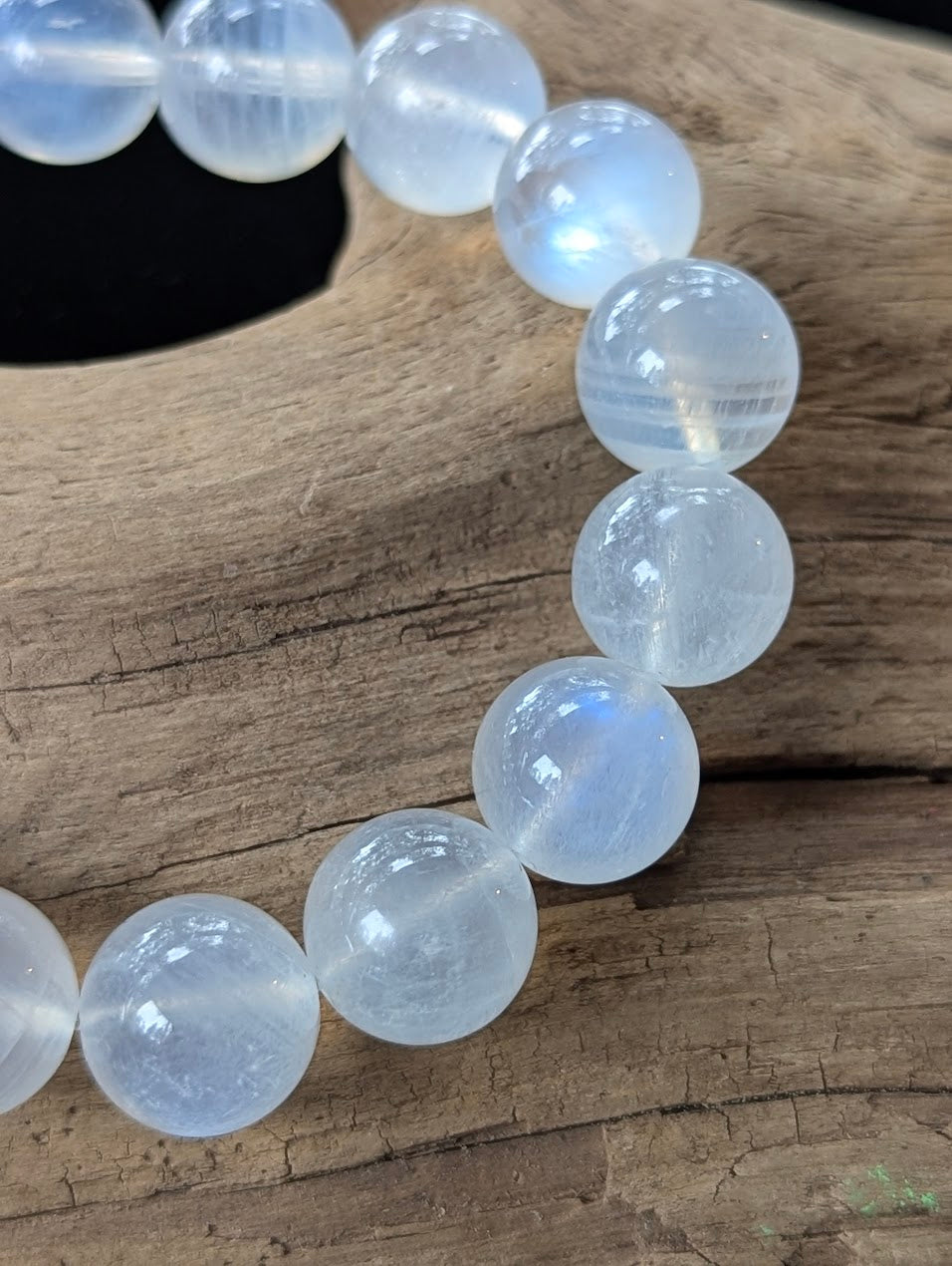 Extreme close-up of 12mm Sri Lankan White Moonstone beads, showing museum-grade clarity and striking adularescence.