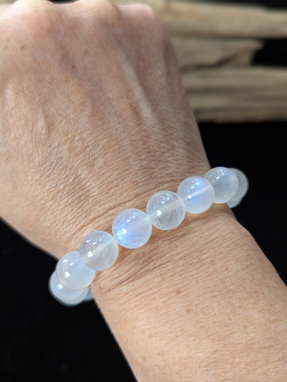 Bold 12mm White Moonstone gemstone bracelet styled on a wrist, offering a prominent display of lunar energy.