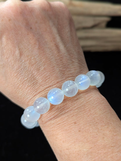Bold 12mm White Moonstone gemstone bracelet styled on a wrist, offering a prominent display of lunar energy.