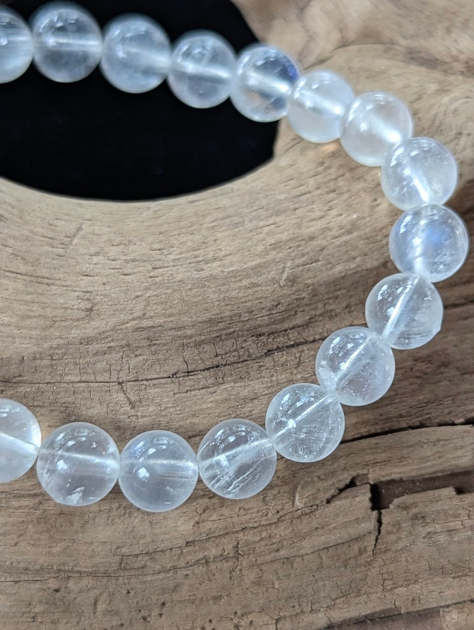 Detailed macro shot of 8mm Sri Lankan White Moonstone beads displaying pristine clarity and natural light refraction.