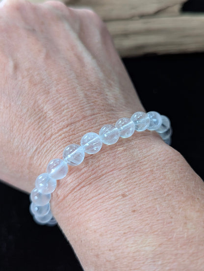 Elegant 8mm White Moonstone gemstone bracelet styled on a wrist, showing excellent scale and bright adularescent glow.