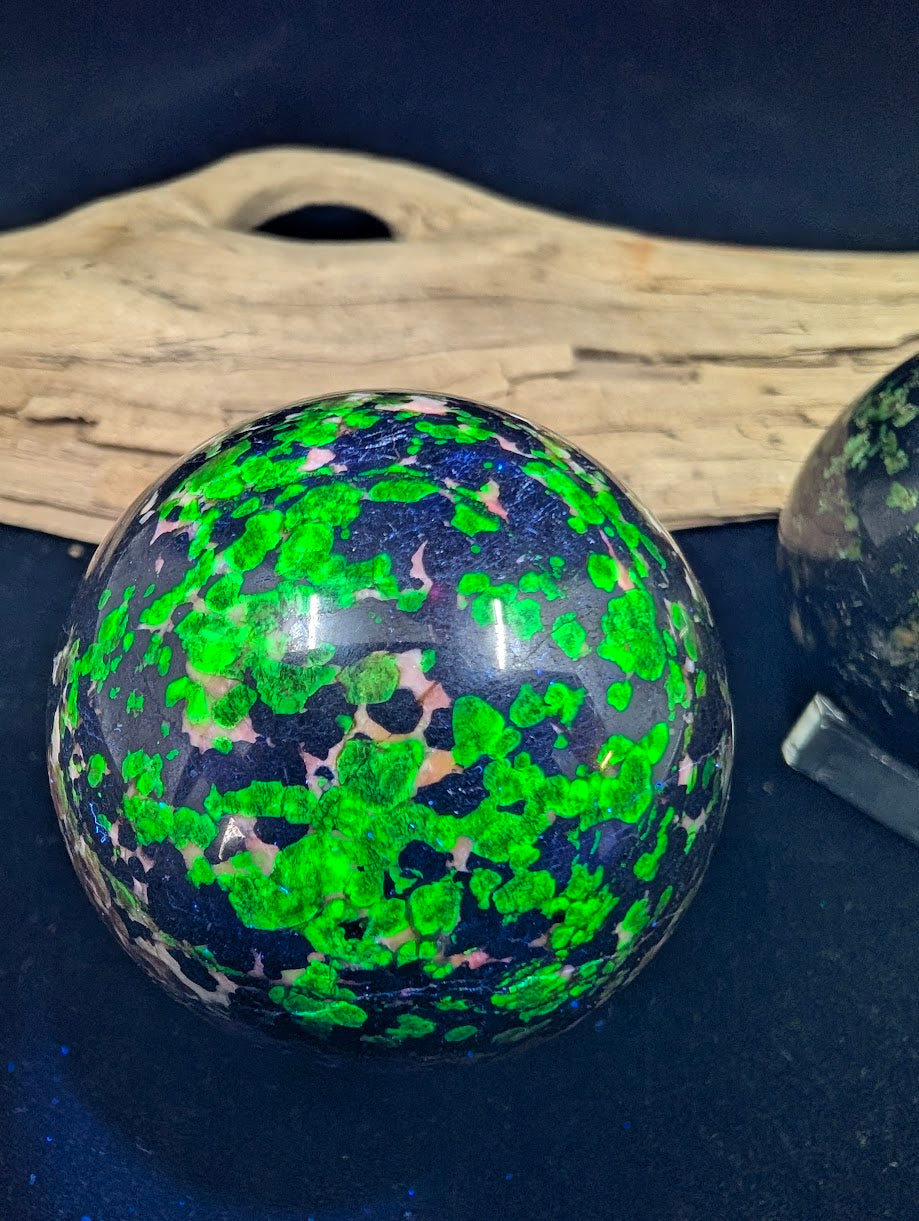 Intense neon green fluorescent pattern on a 50mm sphere activated by shortwave UV light.