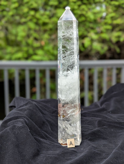 Tower A polished Garden Quartz point showing translucent quartz body with internal veils and mineral inclusions