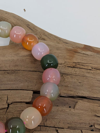 Close-up of Yanyuan agate beads with green, pink, and amber colors