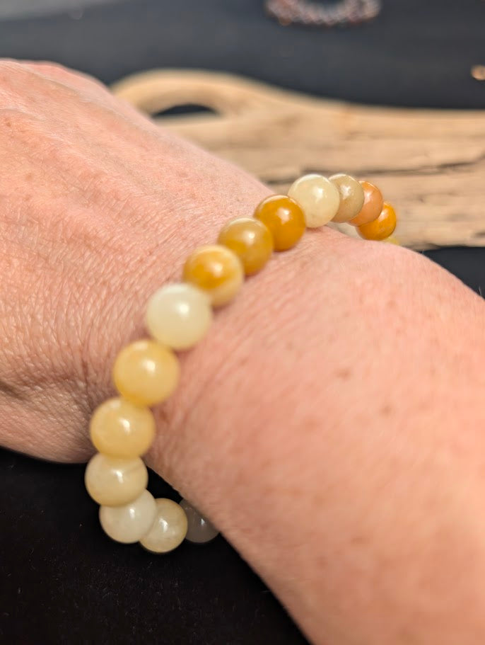 Natural sunlight on an 8mm golden Yellow Aventurine stretch bracelet worn on a wrist.