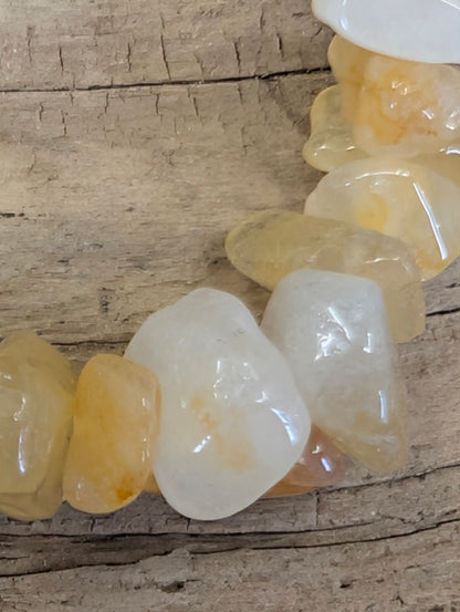 Macro shot of individual Yellow Aventurine chips highlighting the high-gloss finish and natural internal veils.