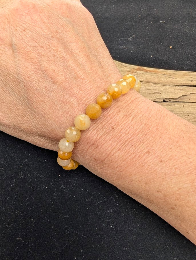 8mm faceted Yellow Aventurine beaded stretch bracelet worn on a wrist for size scale.