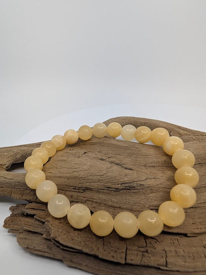 Front view of 8MM Yellow Calcite bracelet on wood background