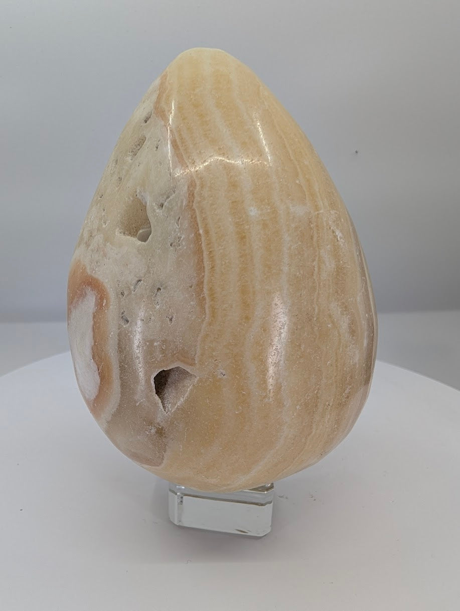 Large polished yellow calcite egg, approximately 1 kg, with warm honey tones and natural banding