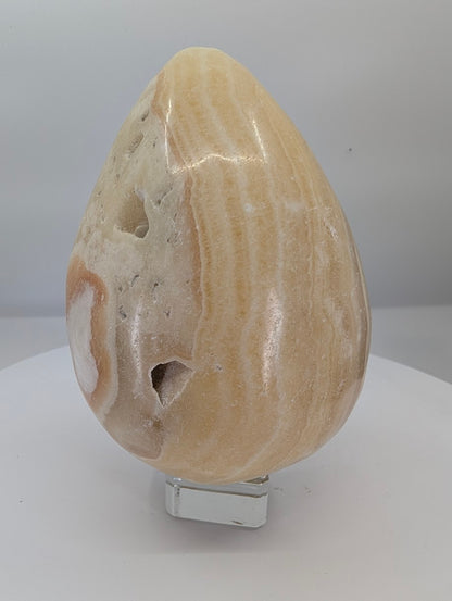 Large polished yellow calcite egg, approximately 1 kg, with warm honey tones and natural banding