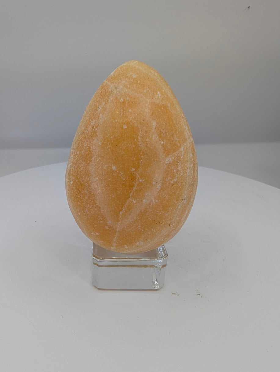Polished yellow calcite egg approximately 2.75 inches tall with warm golden tones and natural banding