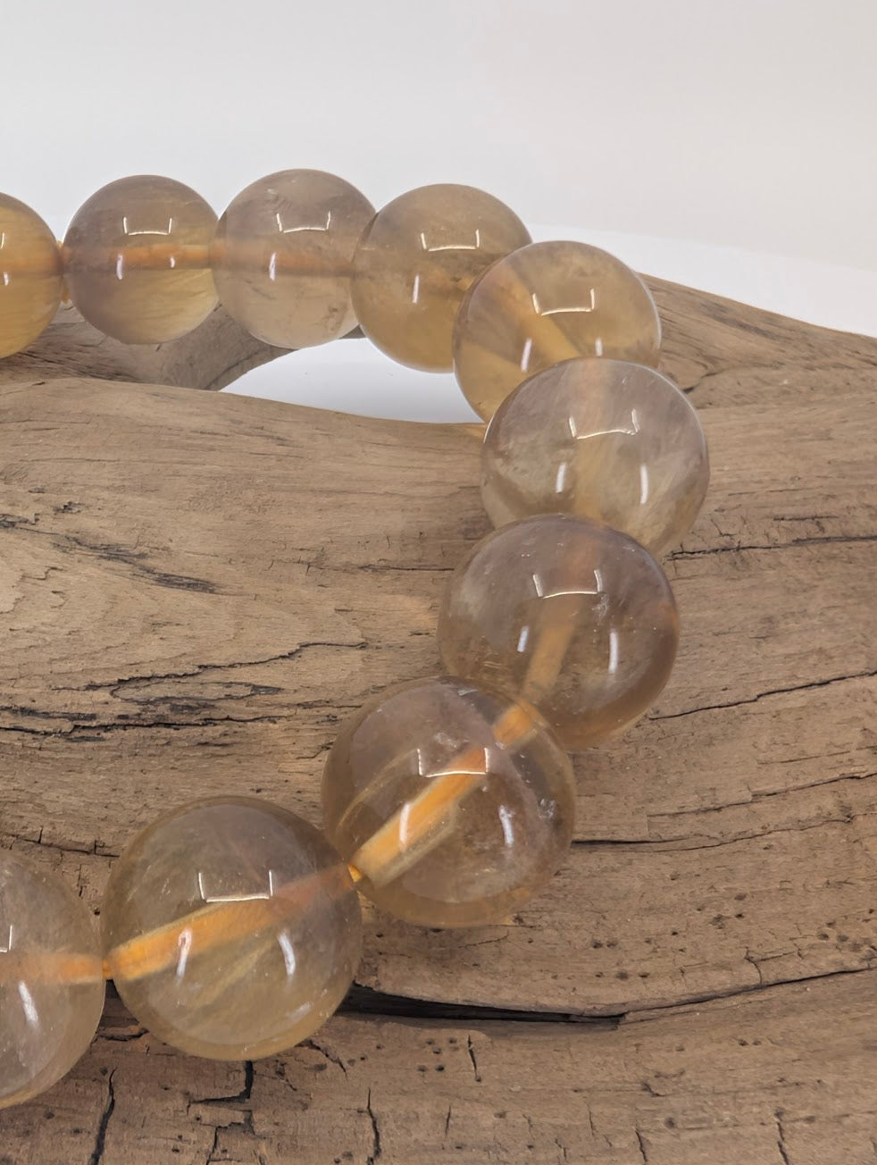 Close-up of 12 mm yellow fluorite beads showing high lustre and clarity