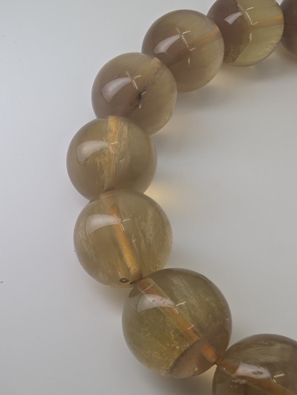 Detailed view of yellow fluorite beads highlighting internal veils and zoning