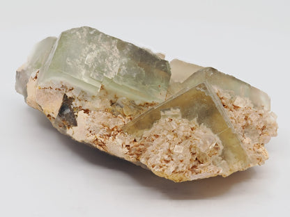 Side view of 255g fluorite specimen showing matrix thickness and crystal habit.