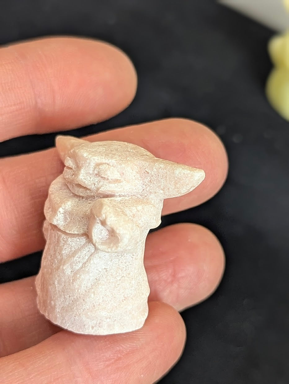 Angled front view of a precision-carved Pink Opal Yoda.