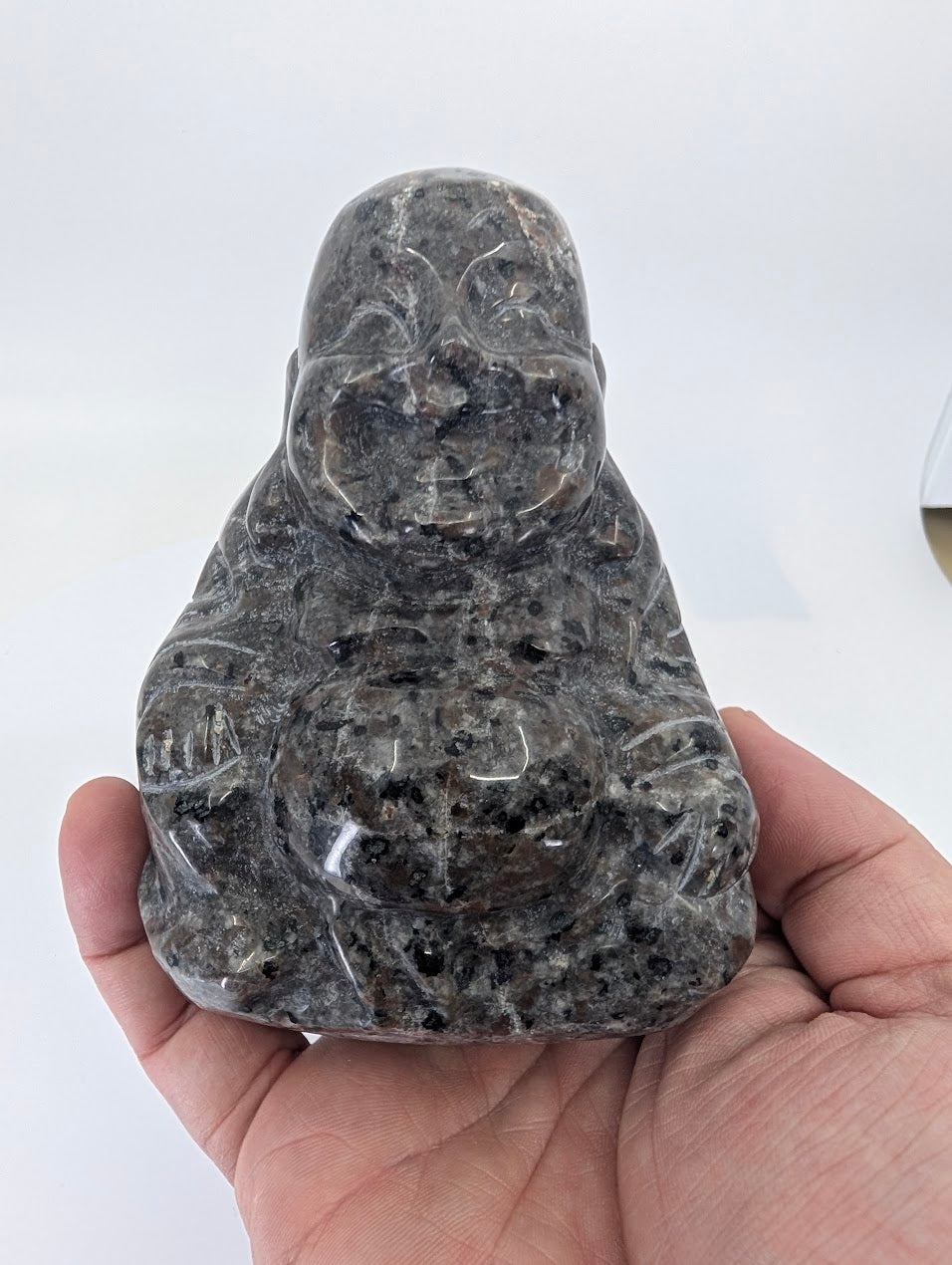 Handheld Yooperlite Laughing Buddha carving highlighting size and polish