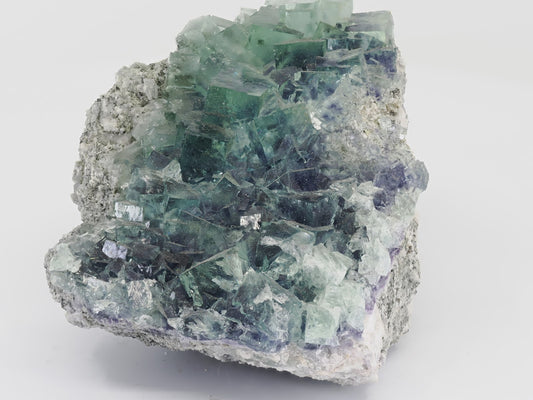 Cabinet-sized blue-green Fluorite cluster from Zhejiang, China, featuring stacked cubic crystals.